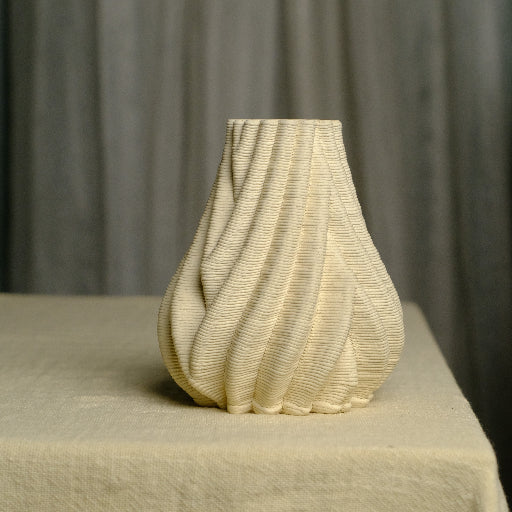 Ceramic bud vase kept on a table. The bud vase is intricately designed and it is 3d printed #color_white