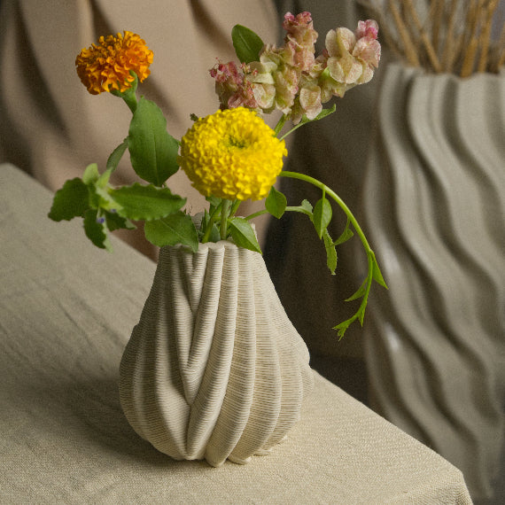 Small ceramic vase with modern design. Small flowers kept inside the ceramic vase #color_white